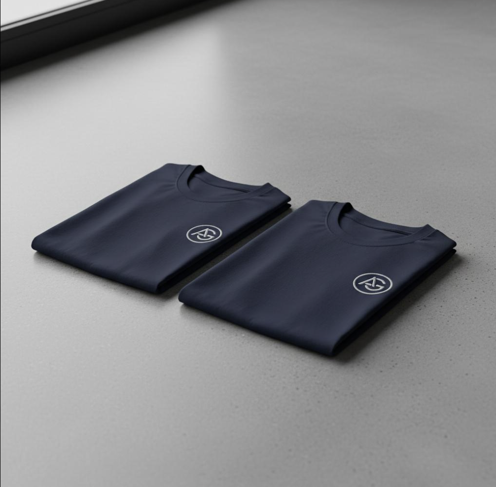 Twee opgevouwen marineblauwe T-shirts met wit cirkellogo op de borst